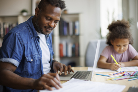 father looking after daughter while reviewing documents