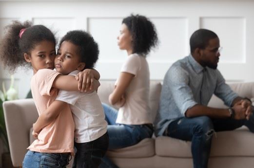 Fairfax children hugging each other while parents argue